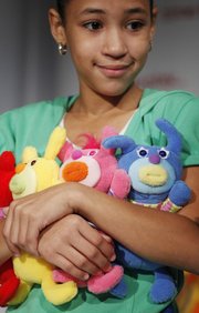 A girl shows off Sing-A-Ma-Jigs, named part of Time To Play’s Holiday 2010 Most Wanted List, in New York in this Sept. 28, 2010 file photo. The plush doll from Mattel will retail for $12.99.