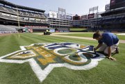 Texas Rangers grounds crew employee Don Crymes puts the final touches on the American League Championship Series logo on the field at the Texas Rangers Ballpark on Wednesday in Arlington, Texas.