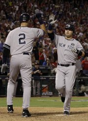 New York’s Derek Jeter (2) greets Nick Swisher after both scored on a bases-loaded single by Alex Rodriguez. The Yankees rallied to win Game 1 of the ALCS, 6-5, on Friday in Arlington, Texas.
