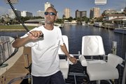 Former mortgage industry executive Jason Altneu, pictured Aug. 17 in South Florida on his boat, now has two jobs: charter boat captain and independent insurance agent. He’s one example of what former construction and mortgage industry workers are doing to transition into new work.
