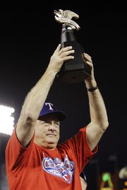 Texas Rangers president and co-owner Nolan Ryan hoists the American League championship trophy on Oct. 22 in Arlington, Texas. Since becoming president in 2008, Ryan has acted as a mentor for the Rangers pitching staff.