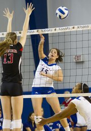 Allison Mayfield (15) spikes the ball past Aubree Piper (13) during Kansas University's volleyball match against Texas Tech Saturday evening at the Horejsi Center.