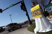 To attract customers, some small businesses plant employees near their business often dressed in costume, holding a sign, which the employee shakes to attract drivers’s attention. Here, sporting a wedding dress, Briton Tomasko, 18, granddaughter of the owners of Park Diamond, tried to drum up business in Maplewood, Minn.