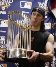 San Francisco Giants pitcher Tim Lincecum holds the World Series trophy after the Giants beat the Texas Rangers, 3-1, on Monday in Arlington, Texas.