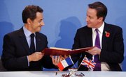 French President Nicolas Sarkozy, left, and Britain’s Prime Minister David Cameron exchange documents during the signing of a treaty at an Anglo-French summit Tuesday at Lancaster House in London. Britain and France vowed to work hand-in-glove as their leaders ushered in an unprecedented era of defense cooperation by agreeing to create a joint force and share nuclear test facilities.