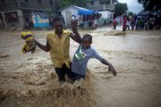 People wade through a flooded street during the passing of Hurricane Tomas on Friday in Leogane, Haiti.