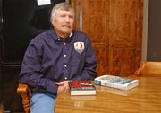 Steve Woelk of Basehor relaxes at his home with two books on the USS Pueblo incident. A member of Tonganoxie VFW Post 9271, he was among 83 men serving on the ship when it was captured by the North Koreans in 1968.
