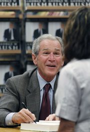 Former President George W. Bush signs a copy of his book “Decision Points” at a store near his Dallas home on Tuesday.