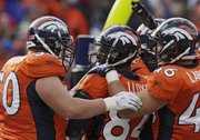 Denver wide receiver Brandon Lloyd (84) is congratulated by teammates after a six-yard touchdown catch. The Broncos beat the Chiefs, 49-29, Sunday in Denver.