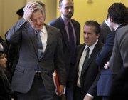 Senate Finance Committee Chairman Sen. Max Baucus, D-Mont., left, holds his head as he walks on Capitol Hill in Washington on Tuesday as negotiations continue on a bill to extended unemployment benefits and preserve tax cuts.