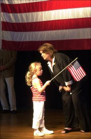 Elizabeth Edwards talks to her daughter Emma Claire, 6, on the stage at Abe & Jake's Landing in Lawrence in this August 2004 file photo. The Edwards family came back to Lawrence to speak after the Democratic presidential campaign train passed by a crowd of 1,000 supporters early Saturday morning without stopping. Edwards died Tuesday after a six-year battle with cancer.