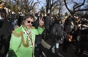 Raymond Brisson, left, of Cranston, R.I., dressed as John Lennon, flashes a peace sign Wednesday as he joins the crowd at the Imagine mosaic in the Strawberry Fields section of New York’s Central Park on the 30th anniversary of Lennon’s death.