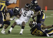 Toledo’s Dan Molls, left, and Isaiah Ballard, right, stop Florida International wideout Wayne Times in the first quarter. FIU beat the Rockets, 34-32, in the Pizza Bowl Sunday in Detroit.