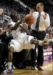 Kansas State guard Martavious Irving (3) tries to keep the ball in bounds as he falls into the North Florida bench while North Florida coach Matthew Driscoll looks on. K-State won, 100-76, Friday in Manhattan.