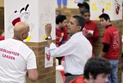 President Barack Obama paints colorful cartoon apples in a student lunchroom at the Stuart Hobson Middle School in Washington as he observes the Martin Luther King Jr. holiday by participating in a community service project on Monday. Martin Luther King Jr. was assassinated in 1968 in Memphis, Tenn.