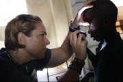 Above, Karin Feltman, a Lawrence Memorial Hospital nurse, performs an eye exam on a boy while serving in Haiti on a 10-day mission trip, one year after a devastating earthquake rocked the country.