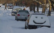 A smiley face greets Lawrence residents on a car parked in the street Wednesday, Feb. 2, 2011. A blizzard hit the city dropping at least 8 inches of snow on Tuesday.