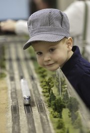 Wearing an engineer hat, Stefen Halm, 5, of Belton, Mo., gets an eyeful of a model train passing Saturday at the Douglas County Fairgrounds. Model train enthusiasts packed into Building 21 for the 10th Annual Lawrence Model Railroad Club Train Show.
