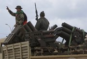 A Libyan gunman flashes a V sign Thursday as he stands on a military truck filled with rocket launchers at Al-Katiba military base after it fell to anti-Libyan Leader Moammar Gadhafi protesters few days ago in Benghazi, Libya.