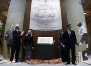 Julian Zugazagoitia, left, director of the Nelson-Atkins Museum of Art; Sarah Rowland; Suzanne Deal Booth; and David Booth, from left, smile after the unveiling of James Naismith&squot;s original rule of "Basket Ball" at the museum Friday, March 4, 2011, in Kansas City, Mo. The Booth family purchased the Rules of Basket Ball at a Sotheby&squot;s auction for more than $4 million; it will be displayed at the museum and will eventually be moved to the Kansas University in Lawrence.