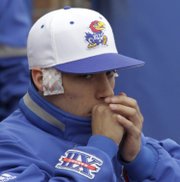 Kansas catcher Carlo Ramirez keeps his ears warm with heating packs as temperatures dropped to 40 degrees during KU’s afternoon game against North Dakota. The Jayhawks won, 5-3, on Wednesday at Hoglund Ballpark.