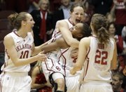 Oklahoma players, from left, Carlee Roethlisberger, Whitney Hand, Jasmine Hartman and Morgan Hook celebrate after defeating Texas Tech. OU won, 71-69, Wednesday in the Big 12 tournament in Kansas City, Mo.