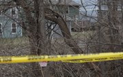 Lawrence police investigate the area where a dead body was discovered Sunday afternoon in a creek bed and wooded area in the 700 block of Michigan Street near Hawk's Pointe I Apartments.