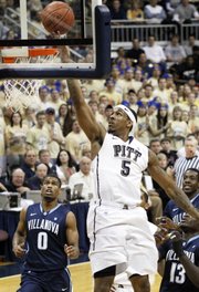 Pittsburgh’s Gilbert Brown (5) drops in a layup between Villanova’s Antonio Pena (0) and Mouphtaou Yarou in the first half of their game Mach 5 in Pittsburgh.
