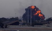 A huge explosion is seen over the outskirts of Benghazi after a warplane was shot down Saturday over Benghazi, eastern Libya. Explosions shook the Libyan city of Benghazi early on Saturday while a Libyan jet fighter was heard flying overhead, and residents said the eastern rebel stronghold was under attack from Muammar Gadhafi’s forces.