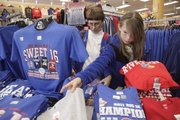 As the Kansas University men’s basketball team prepares to play in the NCAA Sweet 16 in San Antonio, Imy Poteet, Perry, left, and her granddaughter Caitlin Schlesener, 13, Lawrence, picked out their Jayhawks shirts Thursday at Kansas Sampler, 921 Mass. The store said that in the last few days they’ve sold more than 300 T-shirts and some styles have sold out.