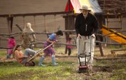 Rick Mitchell, one of the founders of Prairie Moon Waldorf School, works on tilling the garden while children play outside Wednesday, April 6, 2011, at the school.
