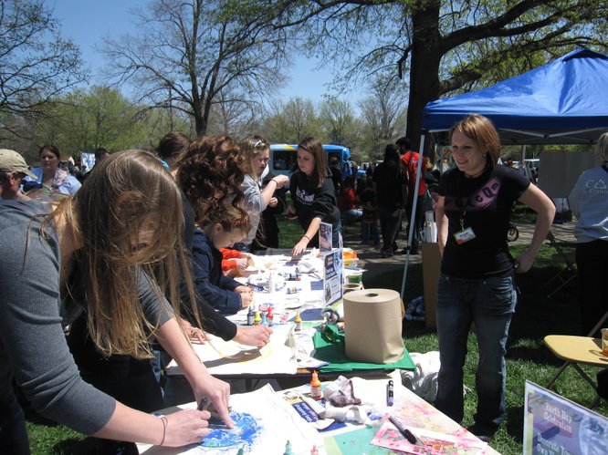 Regan Ramp, left, watches over The Merc's booth at the Earth Day Celebration in South Park. People were decorating reusable shopping bags. By Earth Day, April 22, The Merc — at Ninth and Iowa streets — will no longer carry plastic bags.