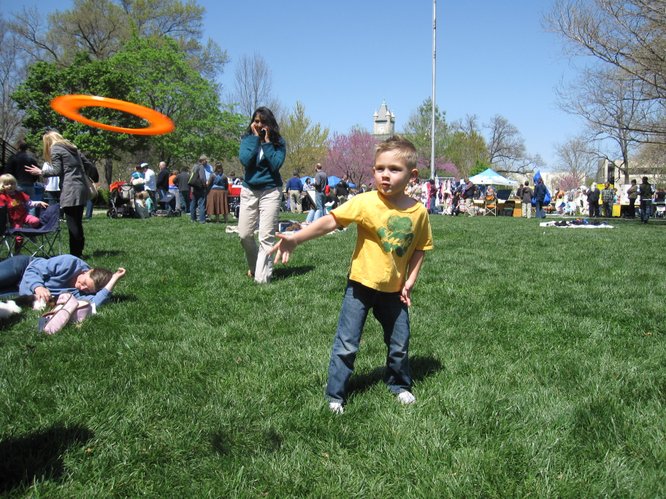 Blaise Brewer, 5, of Lawrence, tosses a Frisbee to his mom, Alice, at the Earth Day Celebration in South Park.