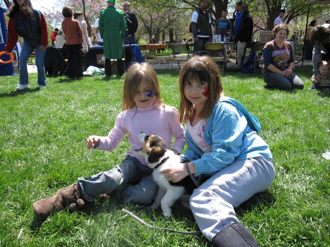 Lexi Grigg, 7, left, and Emily Esparza, 9, play with Lexi's new 9-week-old puppy in South Park during the Earth Day Celebration. The puppy's name will be Suzy or Susie — the family hasn't decided yet.
