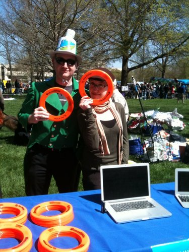 Jonathan Kealing and Jessica Schilling, of The World Company, hand out Frisbees during Earth Day activities Saturday, April 16, 2011, in South Park. They were at the booth for WellCommons and SunflowerHorizons, two community-based websites. WellCommons recently celebrated its one-year anniversary and it about wellness.