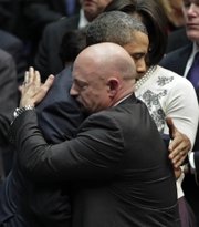 President Barack Obama embraces Mark Kelly, right, the husband of critically wounded Rep. Gabrielle Giffords, D-Ariz., at the end of a ceremony honoring the victims of a shooting rampage in this Jan. 12 file photo. Kelly said his wife has received permission from doctors to attend the launch of the Endeavour on Friday, the last trip for the shuttle and the next-to-last shuttle mission.