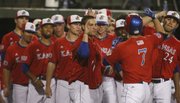 Jimmy Waters (7) is congratulated at home plate after his eighth-inning home run. KU routed Wichita State, 11-2, on Wednesday in Wichita.