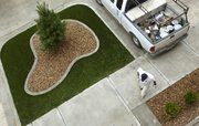 A worker passes an island of fake sod installed at the Tuckaway at Frontier Apartments Thursday, May 5, 2011, as construction continues at the complex. Developers for the project are waiting to hear from city officials about the legality of landscaping with the artificial turf.