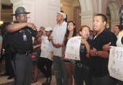 Capt. Leslie Robinson, left, with the Capitol police, asks protestors to leave the Capitol after Georgia Gov. Nathan Deal signed an immigration bill Friday, May 13, 2011, in Atlanta. Almost every state in the union decided to tackle immigration on its own this year in the absence of any federal action on the issue. But an Associated Press review of the data found that as of Wednesday almost all of the punitive measures failed.