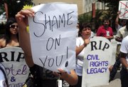 Protestors shout and hold signs outside the Georgia State Capitol May 13, 2011, after Georgia Gov. Nathan Deal signed an immigration bill in Atlanta. Almost every state in the union decided to tackle immigration on its own this year in the absence of any federal action on the issue. But an Associated Press review of the data found that as of Wednesday almost all of the punitive measures failed.