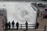People watch water being released through the Oahe Dam's Stilling Basin near Fort Pierre, S.D., Saturday May 28, 2011. U.S. Army Corps of Engineers officials say they have to release more water than previously expected through the Missouri River dams because of expected heavy rains upstream. The corps now plans to maintain releases from Oahe Dam at the current level of 85,000 cubic feet a second until Thursday, June 2, 2011, and then step it up to 150,000 by mid-June - much higher than previously expected.