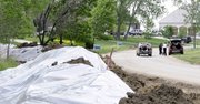 Residents load up possessions near a newly-created dirt levee Monday, May 30, 2011, in Dakota Dunes, S.D. Rising water from the Missouri River is threatening the planned community, which is under a voluntary evacuation order.