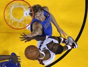 Miami’s Chris Bosh, right, shoots over Dallas’ Dirk Nowitzki in the second half. The Heat beat the Mavs, 92-84, in the first game of the NBA finals on Tuesday in Miami.