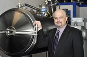 Jeff Edwards stands next to an alkaline hydrolysis device that uses lye and heat to dissolve a body as an alternative to burial or cremation. Proponents say it’s more environmentally friendly than traditional cremation, but skeptics question the safety and social implications of sending someone’s remains down the drain.