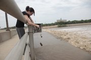 Jillian Rodrigue, assistant director of Douglas County Emergency Management drops a plumb line gauge into the Kansas River to measure the river's flood stage Thursday, June 2, 2011. The county will take measurements every four hours until Saturday morning to monitor the river level. Rodrigue measured the river level at 15-feet, 8-inches at 2:30 p.m., up from 15-feet, 3.5-inches at 10:30 a.m.