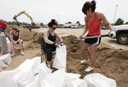 Autumn Bos and Megan Moll fill sand bags along the riverfront Thursday, June 2, 2011, while preparing for the expected flood in Sioux City, Iowa. Gov. Terry Branstad said that all Iowa counties along the Missouri River will be affected by rising water and that residents need to get ready because the worst of the flooding is still upriver.
