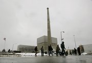 Workers walk past the square building that houses the nuclear reactor at the Oyster Creek nuclear plant in Lacey Township, N.J. Called “Oyster Creak” by some critics because of its aging problems, this boiling water reactor began running in 1969 and ranks as the country’s oldest operating commercial nuclear power plant.