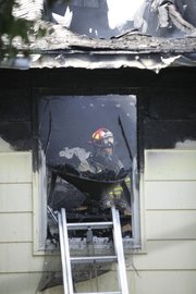 A Lawrence Douglas County Fire & Medical firefighter looks through a damaged window inside a single family home that caught fire about 3:30 p.m. on July 5, 2011. One of the homeowners suffered minor injuries and was taken to Lawrence Memorial Hospital for observation.