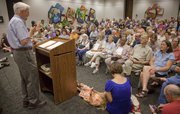 Robert Harder, who has held the position of SRS secretary the longest in state history, speaks to a crowd of about 150 people during a meeting of the Douglas County Democratic Party Saturday, July 9, 2011, at the Lawrence Public Library. Harder said the prevailing political climate at the Statehouse represented a departure from decades of bi-partisan support for social services.