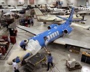 In this Nov. 4, 2004, file photo, workers service Cessna Citation business jets at Cessna's service center in Wichita.